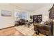 Bright living room with hardwood floors, leather furniture, and natural light from large window at 1348 E Jamison Ave, Centennial, CO 80122