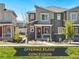 Charming gray two-story townhome with a red front door, stone accents, and well-maintained landscaping at 23527 E 5Th Pl, Aurora, CO 80018