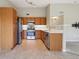 Modern kitchen featuring stainless steel appliances, granite countertops, and wooden cabinetry at 8775 W Berry Ave # 203, Littleton, CO 80123