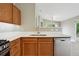 Bright kitchen with stainless steel appliances, wooden cabinets, and an adjacent breakfast bar at 8775 W Berry Ave # 203, Littleton, CO 80123