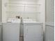 Well-organized laundry area featuring a washer, dryer, and overhead shelving for efficient storage and convenience at 8775 W Berry Ave # 203, Littleton, CO 80123
