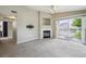Inviting living room featuring a cozy fireplace, ceiling fan, and access to a balcony with a view at 8775 W Berry Ave # 203, Littleton, CO 80123