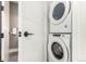 Efficient laundry room with stacked washer and dryer units and sleek white doors at 1901 Wazee St # 807, Denver, CO 80202