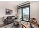 Modern living room with gray sofa, glass coffee table, and balcony access with city views at 1901 Wazee St # 807, Denver, CO 80202