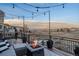 Deck with firepit and string lights offering scenic neighborhood views at 10918 Bellbrook Cir, Highlands Ranch, CO 80130