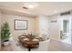 Dining room featuring an oval table with seating for six and adjacent bathroom at 5201 S Fox St # 102, Littleton, CO 80120