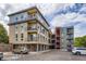 Modern condo building with tan and grey facade, multiple balconies, and convenient parking at 5201 S Fox St # 102, Littleton, CO 80120