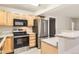Kitchen with wooden cabinets, stainless steel appliances, and modern lighting fixtures at 5201 S Fox St # 102, Littleton, CO 80120
