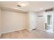 An empty room with wood-look vinyl floors with an open bathroom, white door, and coat hooks at 5201 S Fox St # 102, Littleton, CO 80120