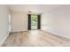 Bright living room featuring light wood floors, neutral walls, and a large window with dark curtains at 5201 S Fox St # 102, Littleton, CO 80120