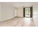 Bright living room featuring light wood floors, neutral walls, and a door to the outside at 5201 S Fox St # 102, Littleton, CO 80120