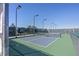 Well-lit pickleball court with a net, fenced-in area for recreational activities and sporting events at 5201 S Fox St # 102, Littleton, CO 80120