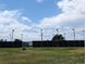 Fenced tennis courts surrounded by tall stadium lights, providing a dedicated recreational space for sport at 5201 S Fox St # 102, Littleton, CO 80120
