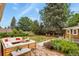 Relaxing backyard features a brick patio, lush lawn, mature trees, and plenty of room to entertain at 4040 Cody St, Wheat Ridge, CO 80033
