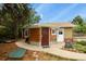 Charming exterior with a unique door and well maintained yard surrounded by mature trees at 4040 Cody St, Wheat Ridge, CO 80033