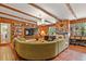 Warm living room with wood paneling, beamed ceilings, built-in bookshelves, and a comfortable green sofa at 4040 Cody St, Wheat Ridge, CO 80033