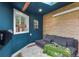 The office space has gray sofa, brick wall, wood floors, and a large window for natural light at 4040 Cody St, Wheat Ridge, CO 80033