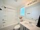 Bright bathroom featuring a shower-tub combo, vanity with modern fixtures, and a large mirror at 5027 N Walden Way, Denver, CO 80249