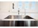 Close up of a kitchen sink with a modern faucet and bright natural light from the windows at 5027 N Walden Way, Denver, CO 80249