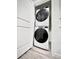 Convenient laundry area featuring stacked washer and dryer units in a compact space at 5027 N Walden Way, Denver, CO 80249
