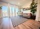 Sunlit living room featuring hardwood floors, a neutral couch, stylish rug, and lots of lush plants at 5027 N Walden Way, Denver, CO 80249
