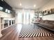 Bright living room with hardwood floors, large windows, a cozy couch, and a custom dog crate at 5027 N Walden Way, Denver, CO 80249