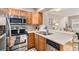 Modern kitchen with stainless steel appliances and light wood cabinets at 8867 W Floyd Ave, Lakewood, CO 80227