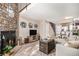 Living room with a stone fireplace and a view of the kitchen and stairs at 8867 W Floyd Ave, Lakewood, CO 80227