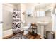 Well-lit bathroom with a pedestal sink, decorative rug, and patterned shower curtain at 6222 Kilmer Loop # 103, Golden, CO 80403