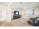Spacious finished basement showcasing a TV with cabinet and black futon at 15691 E Atlantic Cir, Aurora, CO 80013
