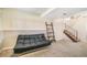 Basement featuring a black futon, ladder shelf and access to the stairs at 15691 E Atlantic Cir, Aurora, CO 80013