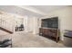 Finished basement showcasing a TV with cabinet, a mini fridge, and access to the stairs at 15691 E Atlantic Cir, Aurora, CO 80013