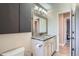 Bathroom featuring a granite countertop, decorative mirror, and custom cabinet at 15691 E Atlantic Cir, Aurora, CO 80013