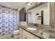 Bathroom featuring a granite countertop, decorative mirror, and a shower/tub combo at 15691 E Atlantic Cir, Aurora, CO 80013