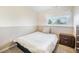 Comfortable bedroom featuring a bed, side table, and window at 15691 E Atlantic Cir, Aurora, CO 80013