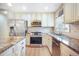 Bright kitchen with stainless steel appliances, granite counters, neutral backsplash, and modern cabinetry at 15691 E Atlantic Cir, Aurora, CO 80013