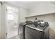 Laundry room with black washer and dryer next to toilet and window at 15691 E Atlantic Cir, Aurora, CO 80013
