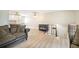 Living room featuring light walls and floors with a view to the kitchen, stairs to the basement, and a dog crate at 15691 E Atlantic Cir, Aurora, CO 80013
