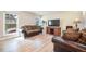 Comfortable living room with two dark leather sofas, a TV, and light walls and flooring at 15691 E Atlantic Cir, Aurora, CO 80013