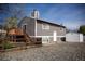 A side yard showing a home with a deck, privacy fence, and stone ground cover at 4087 S Clarkson S St, Englewood, CO 80113