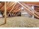 Spacious attic featuring wood flooring and unfinished storage with exposed wooden beams and visible insulation at 7492 W Cedar Cir, Lakewood, CO 80226