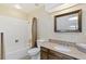 Bathroom with white tiled shower and granite countertop vanity with dark wood cabinets at 7492 W Cedar Cir, Lakewood, CO 80226