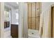 Shower room with tile surround and neutral curtain, adjoined to sink area at 7492 W Cedar Cir, Lakewood, CO 80226