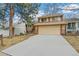 Two-story home showcasing an attached two-car garage and a wide driveway at 7492 W Cedar Cir, Lakewood, CO 80226