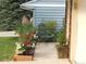 Charming front yard featuring flowering plants, a decorative chair, and a well-maintained sidewalk at 7492 W Cedar Cir, Lakewood, CO 80226