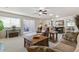 Living room showcases a ceiling fan, comfortable seating, and a sliding glass door to the patio at 7492 W Cedar Cir, Lakewood, CO 80226