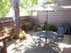 Inviting outdoor patio with dining set, umbrella, and cozy seating area with colorful potted plants at 7492 W Cedar Cir, Lakewood, CO 80226