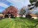 Lush green yard featuring mature trees, flowering shrubbery, and a well-maintained lawn at 7492 W Cedar Cir, Lakewood, CO 80226