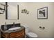 Elegant powder room featuring a vanity with a stone countertop and decorative mirror at 76 Mineola Ct, Boulder, CO 80303