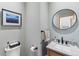 Powder room featuring a sleek vanity, modern fixtures, decorative mirror, and a framed landscape art piece for added appeal at 293 Settlers Dr, Breckenridge, CO 80424